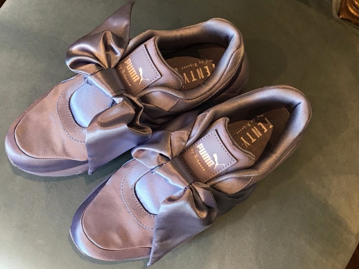 Purple Lavender Sneakers with Bows Resting on a Light Blue Background