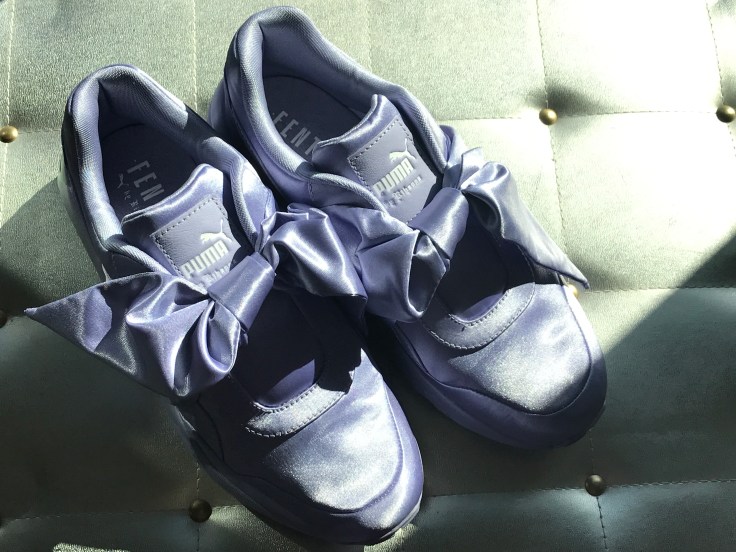 A Pair of Purple Lavender Sneakers with Bows on a Silver Background