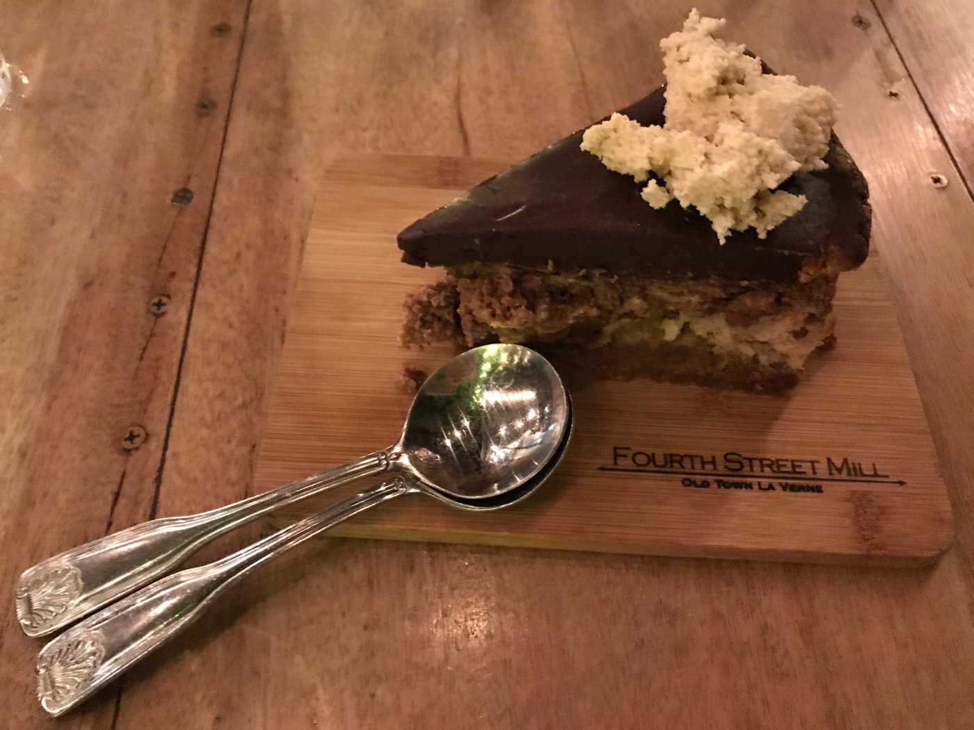 A Slice of Chocolate Peanut Butter Cheesecake Sits Beside Two Spoons at Fourth Street Mill in La Verne, California