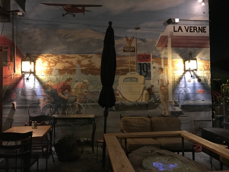 A Mural with Bikers, a Gas Station and a Plane by Local Artist Eric M. Davis at Fourth Street Mill in La Verne, California