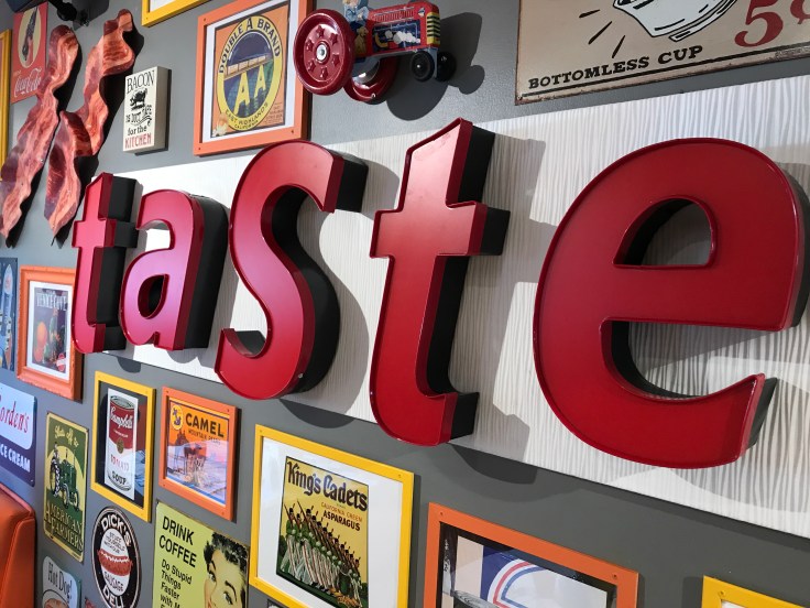 A Sign in Scrambl'z in San Jose, California Says "TASTE" and Cute Vintage Signs and Labels Surround it