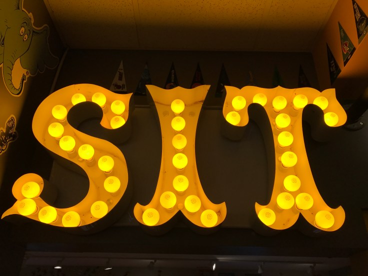 A Neon Sign that Says "SIT" Lights Up a Hallway in Scrambl'z in San Jose, California