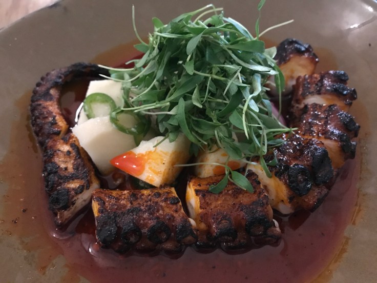 Grilled Octopus at KYU Restaurant in Miami, Florida Served with Hearts of Palm and Red Onion