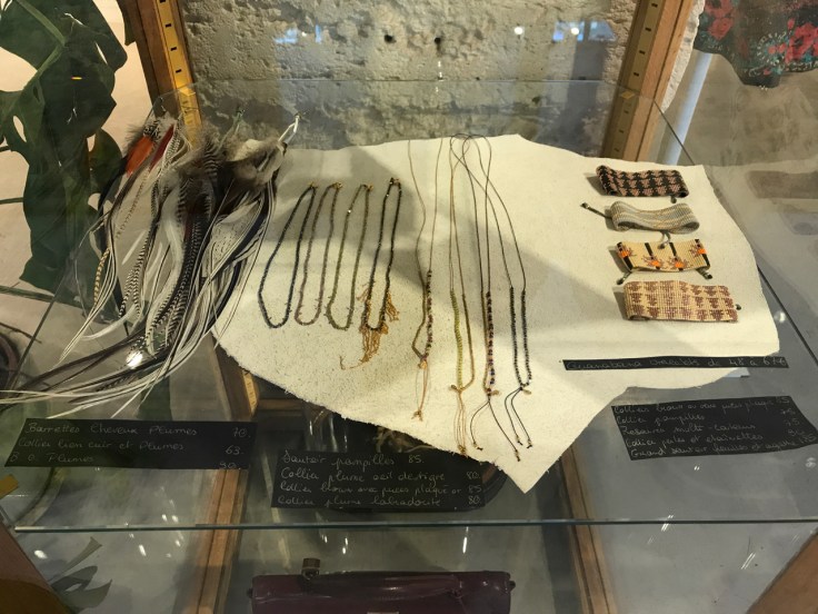 A photo of a jewelry display case featuring feather earrings, bracelets and necklaces from Leon & Harper. The store's boutique in Le Marais is located on Boulevard Beaumarchais in Paris, France.