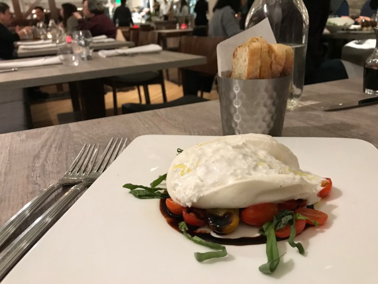 A photo of Morsey's Farm Burrata on the table at Morsey's Farmhouse Kitchen in Los Altos, California. The burrata is made from water buffalo milk and is served with tomato jam, olive oil, balsamic vinegar, basil and maldon salt.