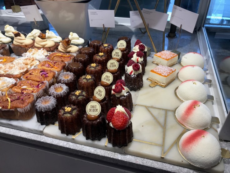 A photo of caramel canelés, vanilla canelés, strawberry canelés, exotic tarts and other pastries at Élan Café in London, England.