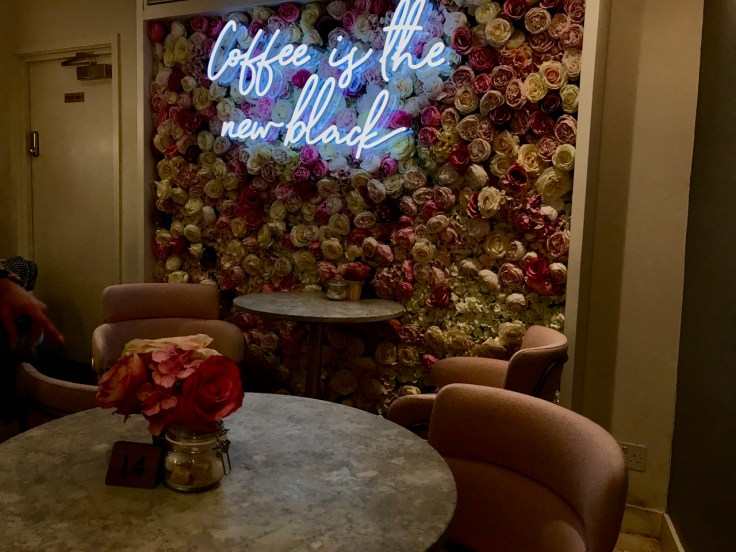 A photo of the tables near the rose flower wall inside Élan Café in London, England.