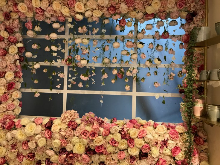 A photo of a window surrounded by a wall of roses at Élan Café in London, England.