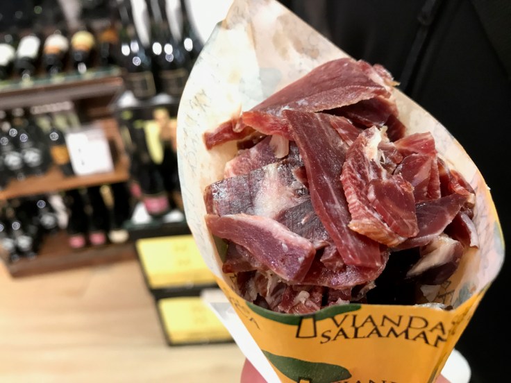 A photo of jamón in a cone or meat cones at Viandas De Salamanca in London, England. A paper cone an ample amount of freshly sliced meat.