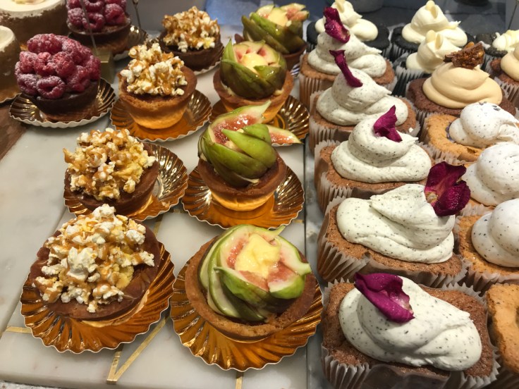 A photo of beautiful pastries at Élan Café in London, England including the caramel popcorn blondies, fig tarts and mini banana breads.