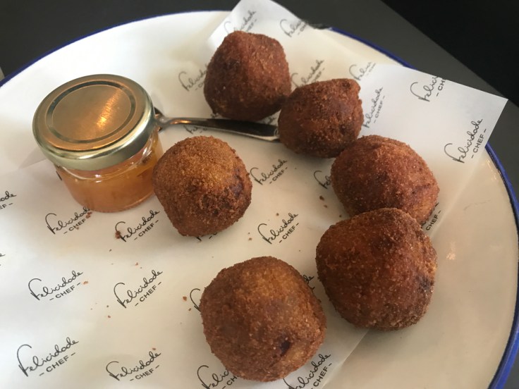 A photo of duck croquettes served with orange jam (croquetes de pato com compota de laranja) at Pharmacia restaurant in Lisbon, Portugal.
