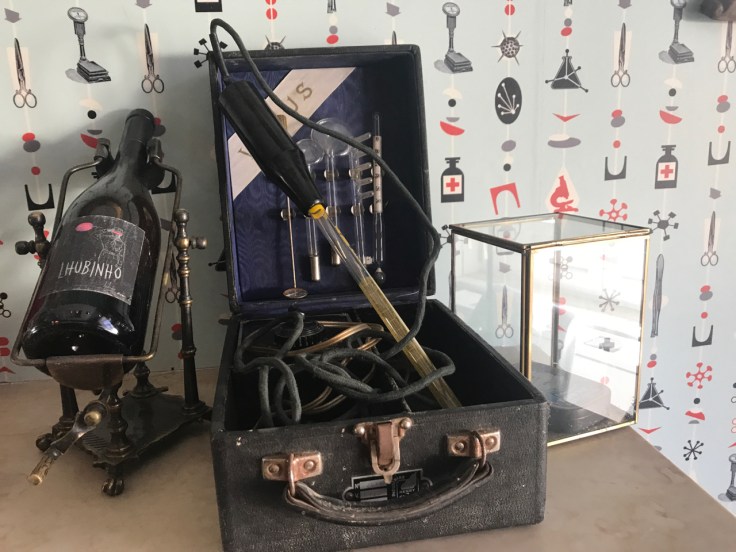 A photo of pharmacy inspired wallpaper, syringes and other medicine inspired trinkets at Pharmacia restaurant in Lisbon, Portugal.