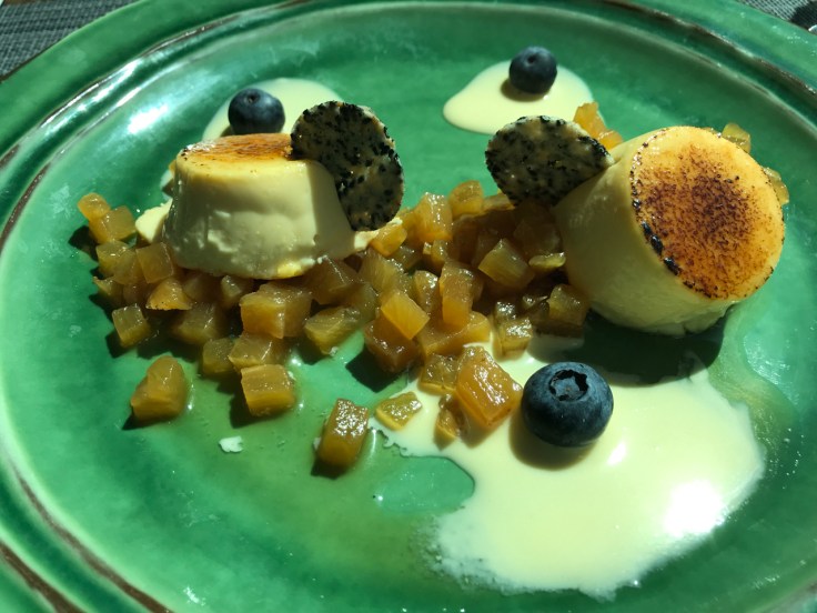 A photo of the kaffir lime crème brûlée at Organic Caffe in Estoril, Portugal. It's topped with toasted coconut sauce and a caramelized pineapple brunesa that is made with Madagascar vanilla. Crème brûlée de lima kafir, molho de coco tostado e brunesa de abacaxi caramelizado com baunilha de Madagascar