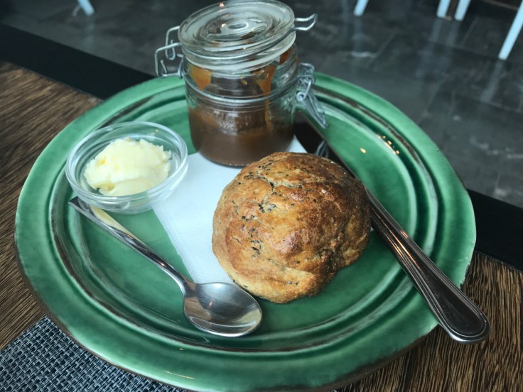 A photo of an oat scone with pumpkin jam and coconut sugar (scone de aveia com compota de abóbora e de açúcar de coco) at Organic Caffe in Estoril, Portugal.
