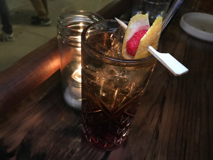 A photo of a raspberry Negroni sbagliato aperitivo cocktail made with vermouth and sparkling spumante at The Snug SF in San Francisco, California.