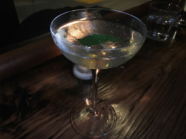 A photo of The Snug SF's Potent White Lily #2 cocktail in San Francisco, California. It's made with with gin, rum, orange liqueur, absinthe and curry leaf.