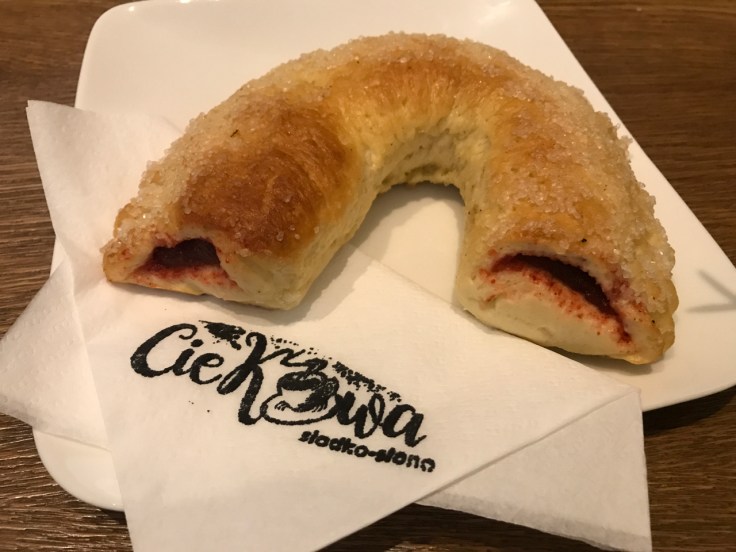 A photo of a u-shaped drożdżówka stuffed with berry filling at Ciekawa Słodko-Słono restaurant in Tarnów, Poland. Drożdżówka are sweet polish rolls you can find at shops in Poland.