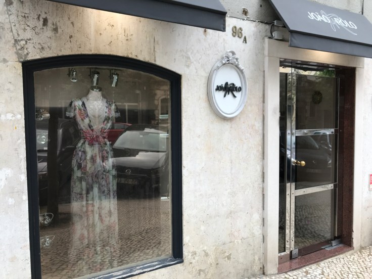 An exterior street view photo of the outside front of João Rôlo Couture (an haute couture dress and gown shop) taken from the sidewalk in Lisbon, Portugal. Photo Courtesy of FoodWaterShoes
