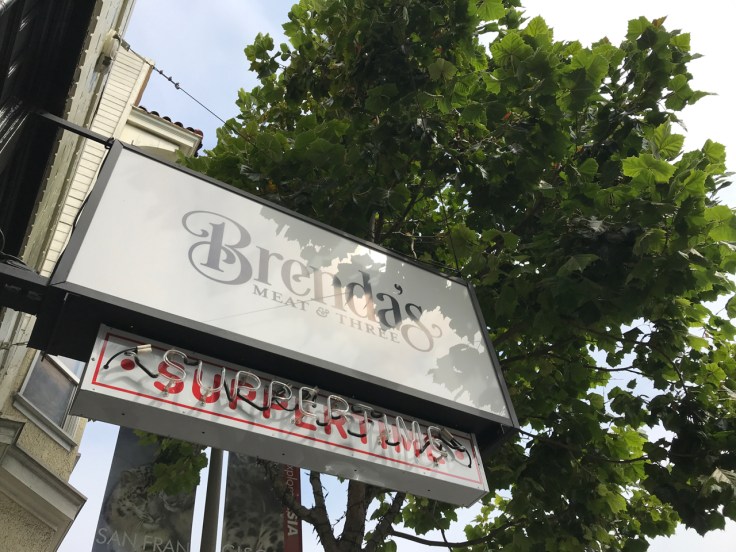 An exterior street view photo of the outside front of Brenda's Meat & Three restaurant in San Francisco, California.