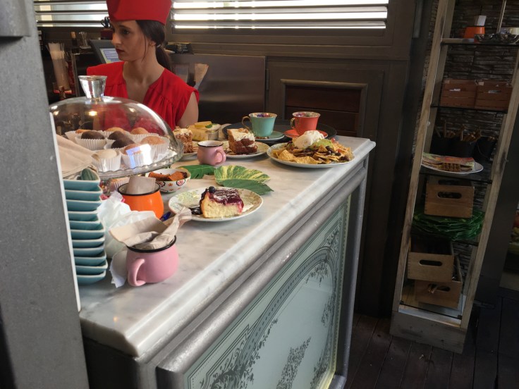 A waitress in a red outfit prepares beautiful beverages and food at a prep counter for hungry diners at El Jardín de SB (Salvador Bachiller Gastrobares) restaurant in Madrid, Spain. Photo Courtesy of FoodWaterShoes