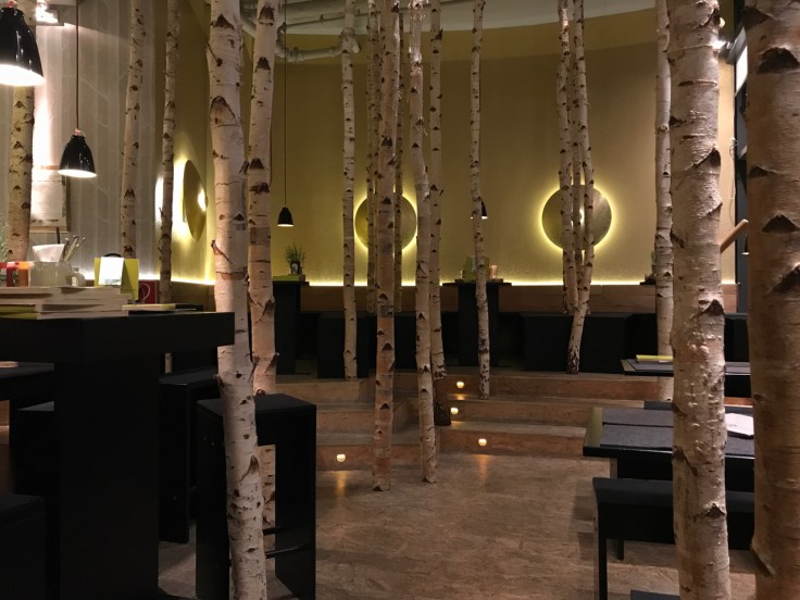 Tables in the restaurant are surrounded by a faux birch forest full or trees at Hans im Glück burger grill in Stuttgart, Germany. Photo Courtesy of FoodWaterShoes