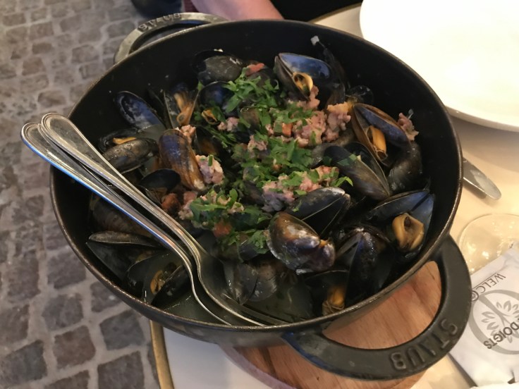 Steamed mussels (moules cochon façon hortense) in a cast iron dish are one of the many popular dishes you can eat at Au Pied de Cochon restaurant in Paris, France.
