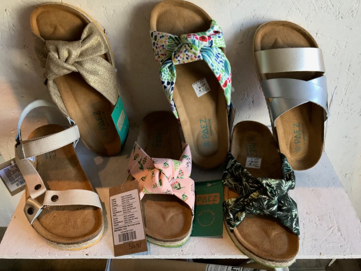 Six sandals in different brightly colored styles and prints sit on display at the Paez shoe store in Porto, Portugal. Photo Courtesy of FoodWaterShoes