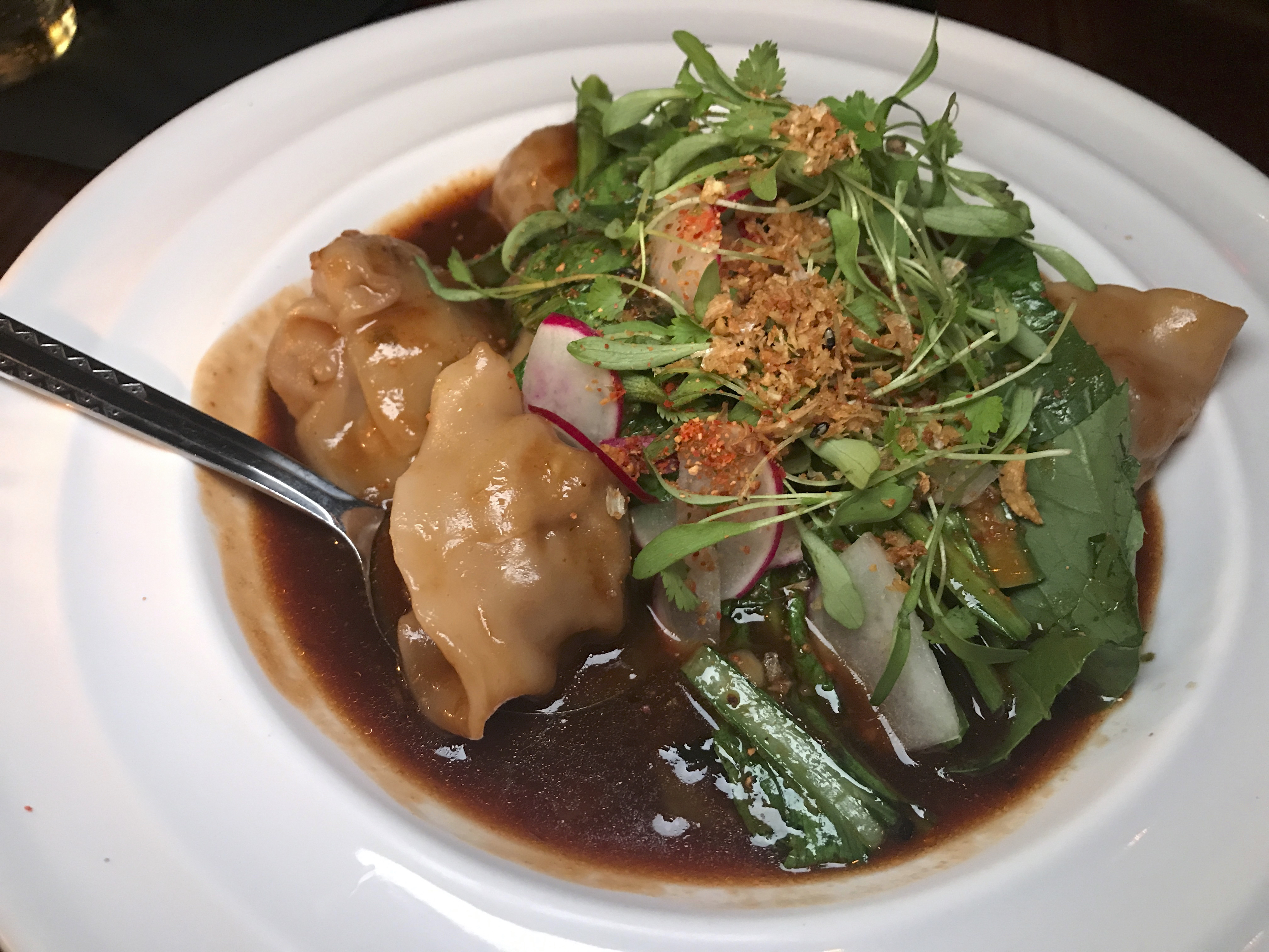 A photo of the pork belly dumplings at Shōjō, a local Asian restaurant in Boston, Massachusetts' downtown Chinatown. The dish features sake hoisin, jalapeños, radishes and cilantro. Photo Courtesy of FoodWaterShoes