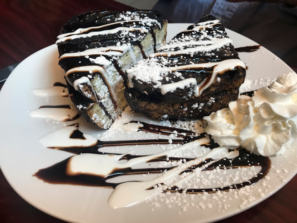 A photo of Oreo stuffed French toast at local hot spot Modern Malt in Syracuse, New York. The toast is filled with Oreo buttercream and drizzled with chocolate and marshmallow sauce. Modern Malt is an upstate New York CNY based diner that serves breakfast, lunch and dinner. Photo Courtesy of FoodWaterShoes