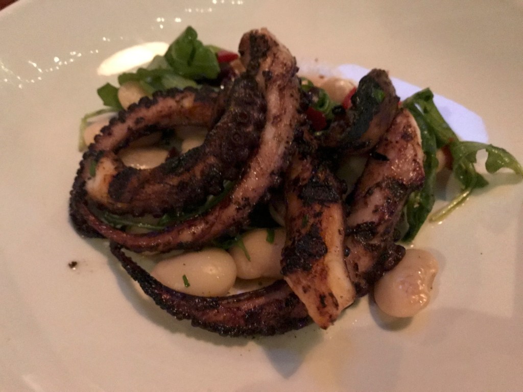 A photo of a charred octopus appetizer at local hot spot Mindy's Hot Chocolate Chicago in Chicago, Illinois. The dish is made with charred octopus, marinated gigante beans, kalamata olives, Calabrian chiles, oregano and lemon. The Windy City based dessert restaurant serves brunch, cocktails, drinks, lunch and dinner. Photo Courtesy of FoodWaterShoes