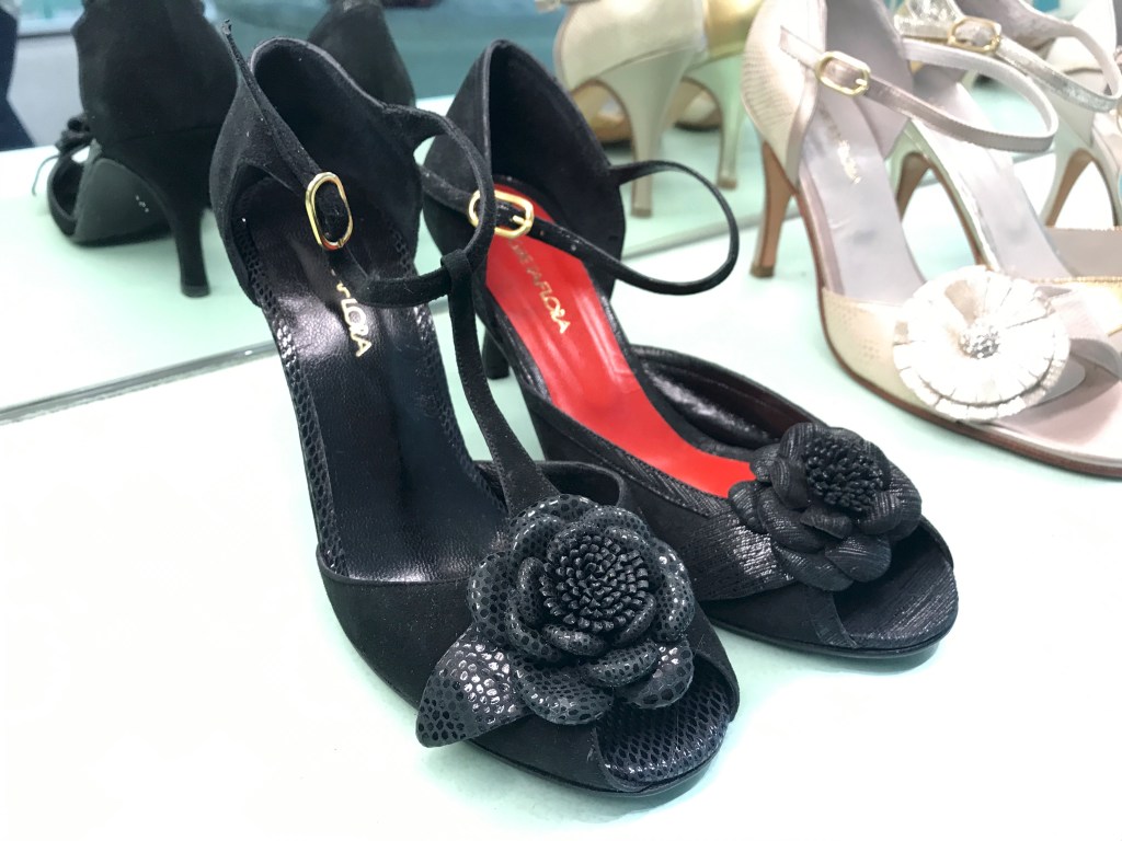 A photo of eye catching black tango high heels with flowers on them at the GretaFlora shoe shop in Buenos Aires, Argentina. If you're interested in fashion and stiletto shopping in Buenos Aires, this is one boutique you won't want to miss. Photo Courtesy of FoodWaterShoes