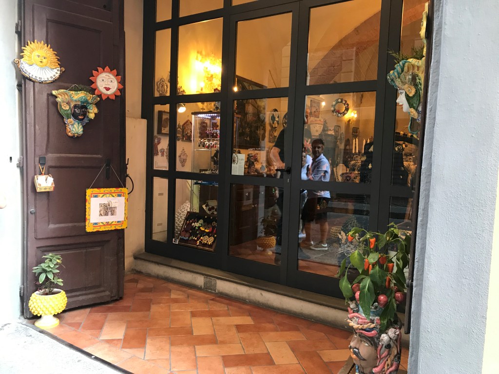 A photo of the front door to Sikuliana Art Atelier, a Sicilian ceramics and jewelry store in Florence, Italy. The photo is of the exterior / is an outside street view shot of the accessories boutique. Photo Courtesy of FoodWaterShoes