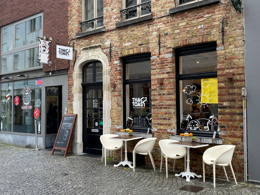 A photo of the patio outside exterior street view of That's Toast, a cute little café restaurant in Bruges, Belgium. Photo Courtesy of FoodWaterShoes
