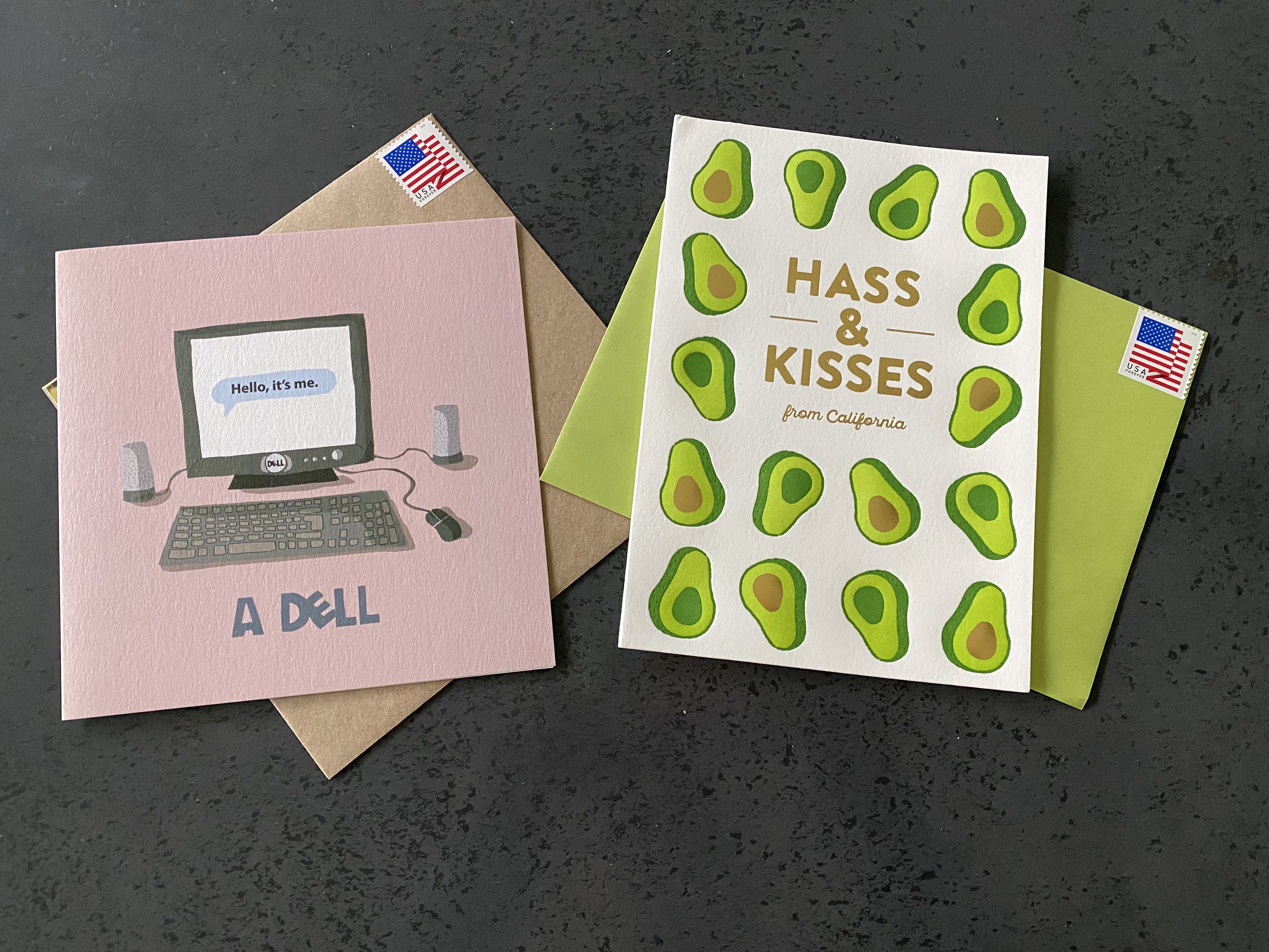 A photo of two funny punny greeting cards. One designed by Ohh Deer says, "Hello, It's me. A dell." Another card by Elum Designs says, "Hass & Kisses From California." Photo Courtesy of FoodWaterShoes